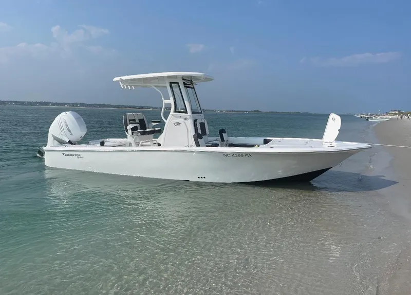 Slide: The Image of 2023 Tidewater 2500CB boat anchored on a sandy beach with clear blue water. - 5