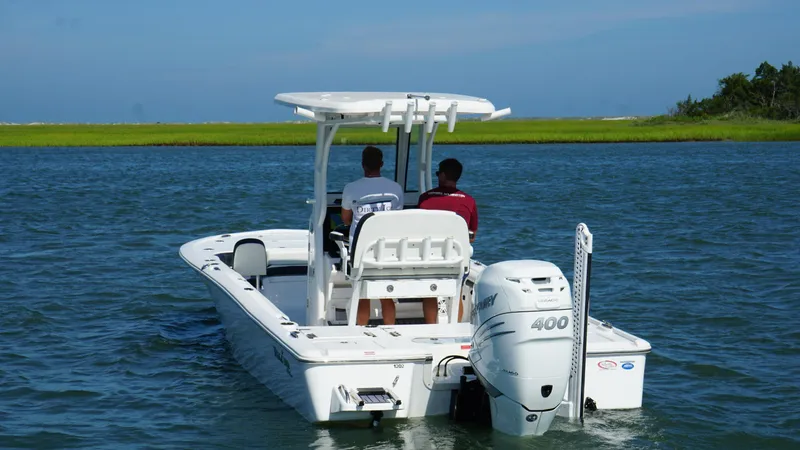 Slide: The Image of 2023 Tidewater 2500CB boat cruising on a calm lake with two passengers. - 6