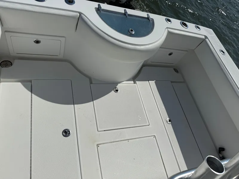 Slide: The Image of 2017 Onslow Bay 27 boat deck with storage compartments and rod holders. - 11