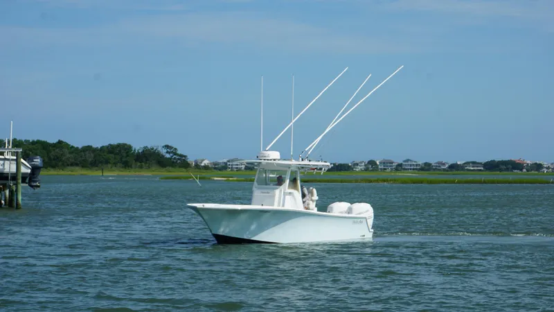 Slide: The Image of 2017 Onslow Bay 27 boat cruising on a calm waterway with distant shoreline. - 2