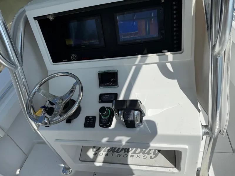 Slide: The Image of 2017 Onslow Bay 27 boat console with steering wheel and electronic controls. - 3