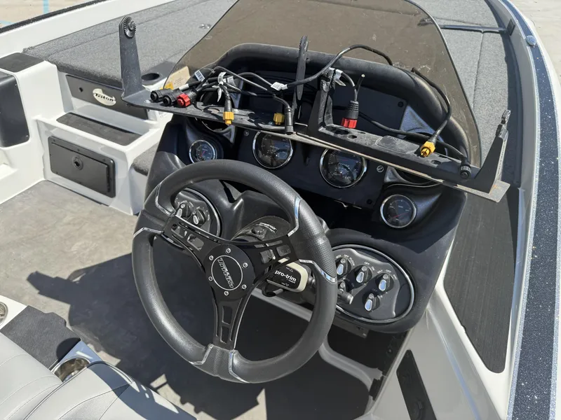 Slide: The Image of 2023 Triton 19 TrX Patriot boat dashboard with steering wheel and control panel. - 13