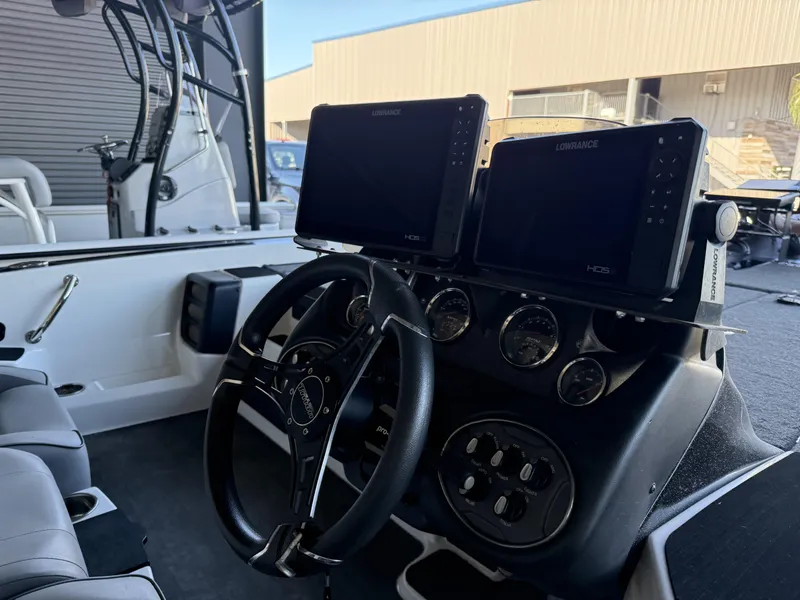 Slide: The Image of 2023 Triton 19 TrX Patriot boat dashboard with dual Lowrance HDS displays and steering wheel. - 22