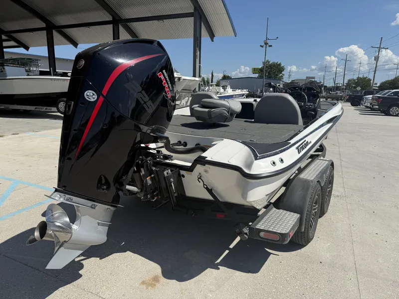 Slide: The Image of 2023 Triton 19 TrX Patriot boat with powerful outboard motor, parked on a trailer. - 3