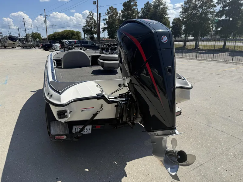 Slide: The Image of 2023 Triton 19 TrX Patriot boat with powerful outboard motor, parked outdoors. - 4