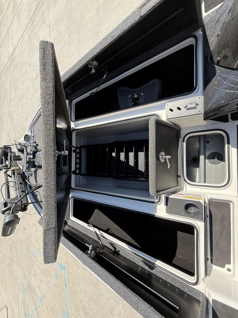 Slide: The Image of 2023 Triton 19 TrX Patriot boat interior with open storage compartments and equipment. - 5