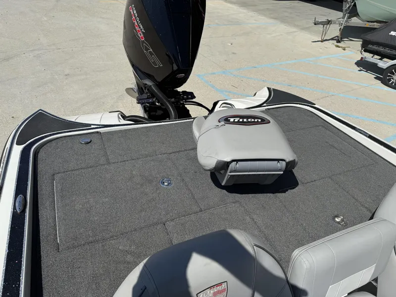 Slide: The Image of 2023 Triton 19 TrX Patriot boat deck with motor and seating. - 8