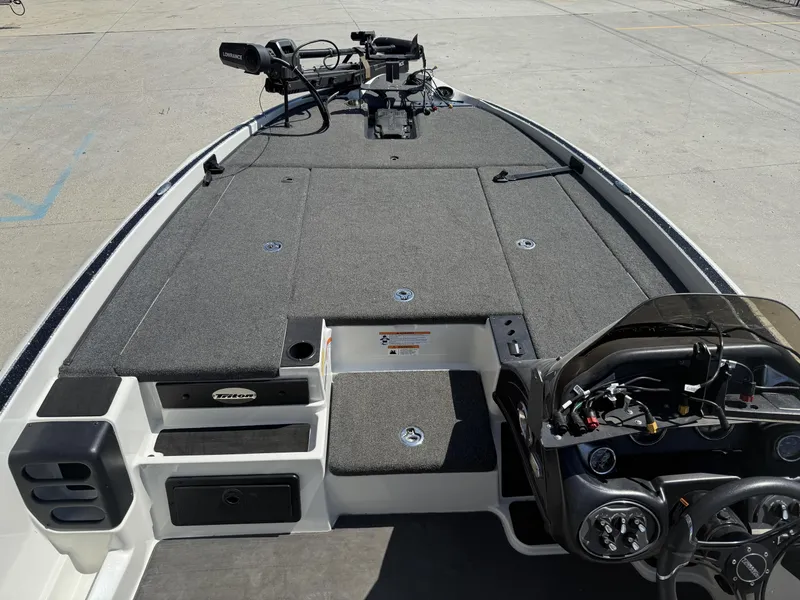 Slide: The Image of 2023 Triton 19 TrX Patriot boat interior with steering console and deck layout. - 9