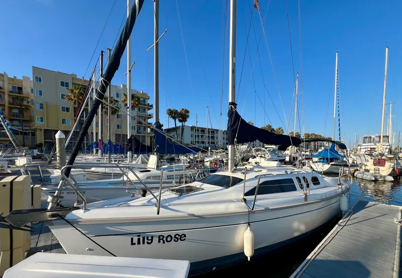 The Image of 1995 Hunter 29.5 sailboat docked in marina under clear blue sky. - 1