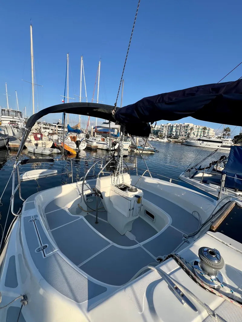 Slide: The Image of 1995 Hunter 29.5 sailboat docked in marina, clear blue sky, multiple boats in background. - 11