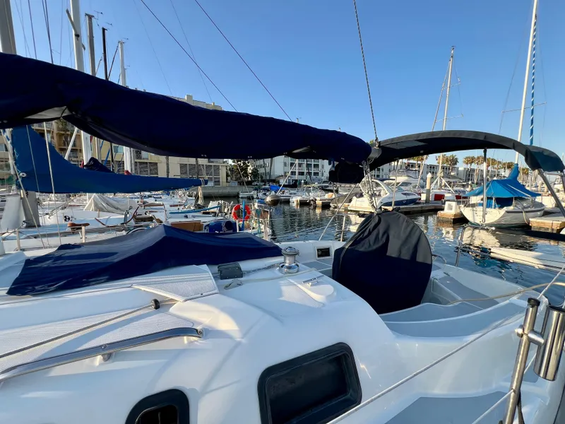Slide: The Image of 1995 Hunter 29.5 sailboat docked in a marina under clear blue skies. - 14