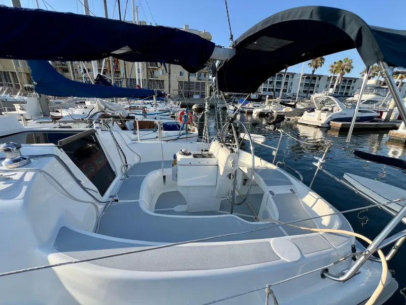 Slide: The Image of 1995 Hunter 29.5 sailboat docked in marina, featuring spacious cockpit and blue canopy. - 15
