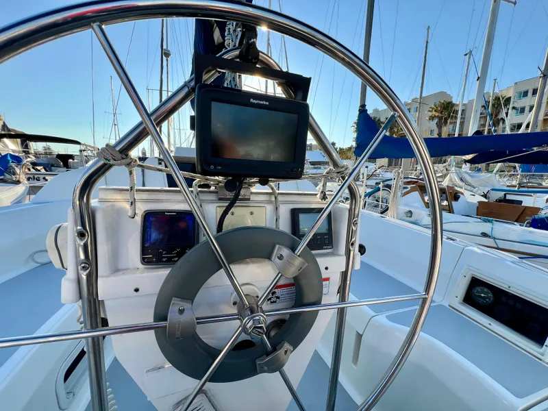 Slide: The Image of 1995 Hunter 29.5 sailboat cockpit with steering wheel and navigation equipment. - 21