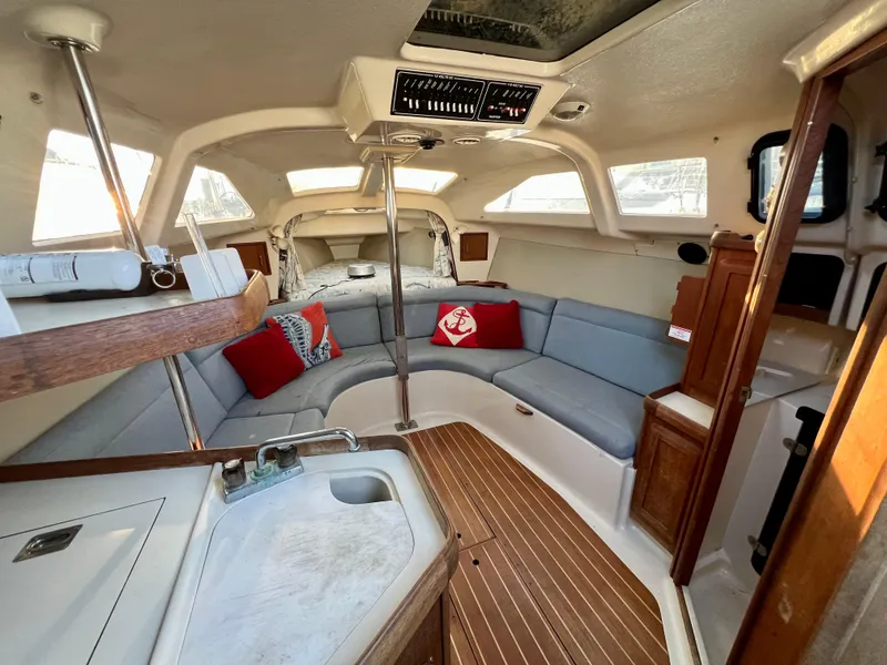 Slide: The Image of Interior of a 1995 Hunter 29.5 sailboat with cozy seating and nautical decor. - 29
