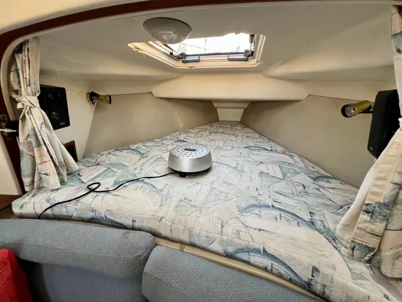 Slide: The Image of Cozy cabin interior of a 1995 Hunter 29.5 sailboat with patterned bedding and curtains. - 30