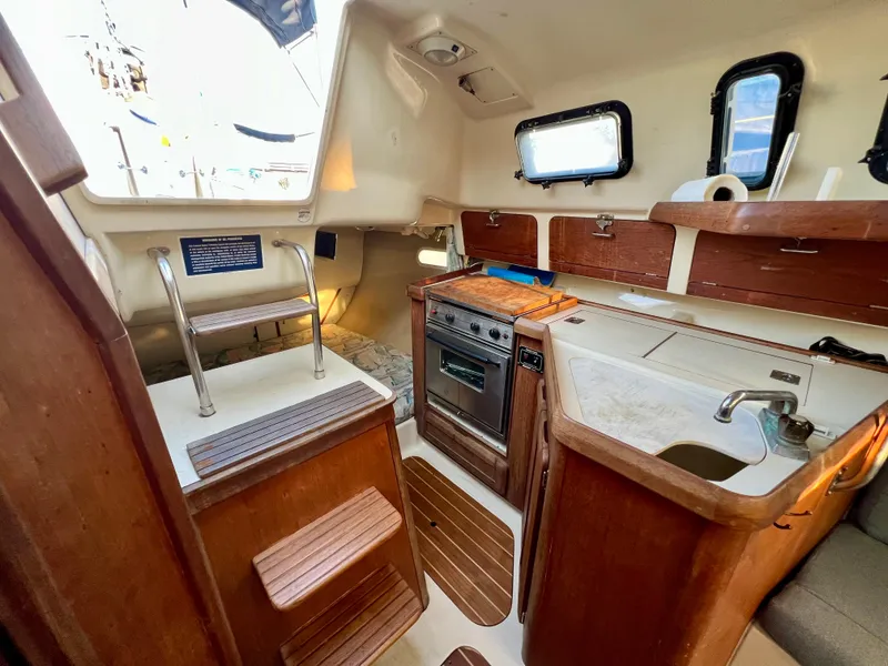 Slide: The Image of Interior of 1995 Hunter 29.5 sailboat with kitchen and wooden cabinetry. - 34