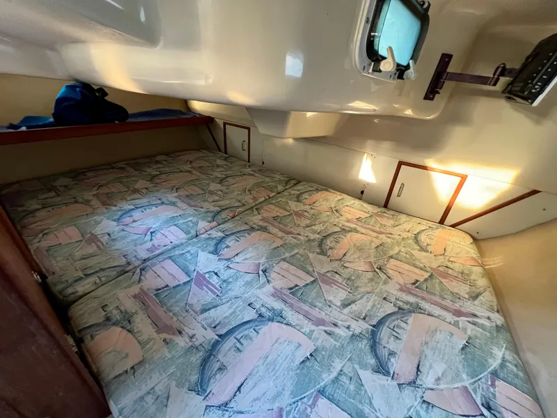 Slide: The Image of 1995 Hunter 29.5 sailboat cabin interior with patterned bedding and storage compartments. - 35