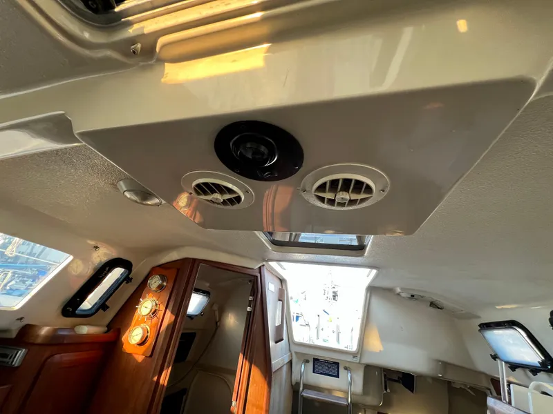 Slide: The Image of Interior of a 1995 Hunter 29.5 sailboat, featuring ceiling vents and wooden cabinetry. - 37