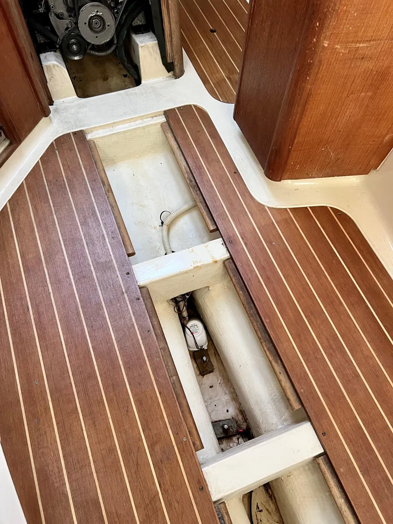 Slide: The Image of Interior view of a 1995 Hunter 29.5 sailboat, featuring wooden flooring and engine compartment. - 42