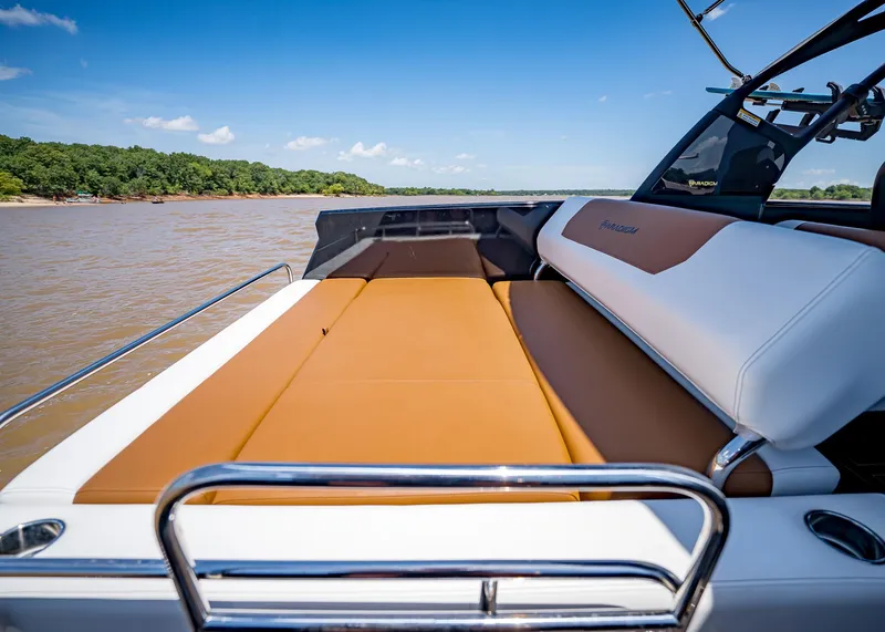 Slide: The Image of 2025 Paradigm 236 boat interior with tan and white seating on a sunny day. - 11
