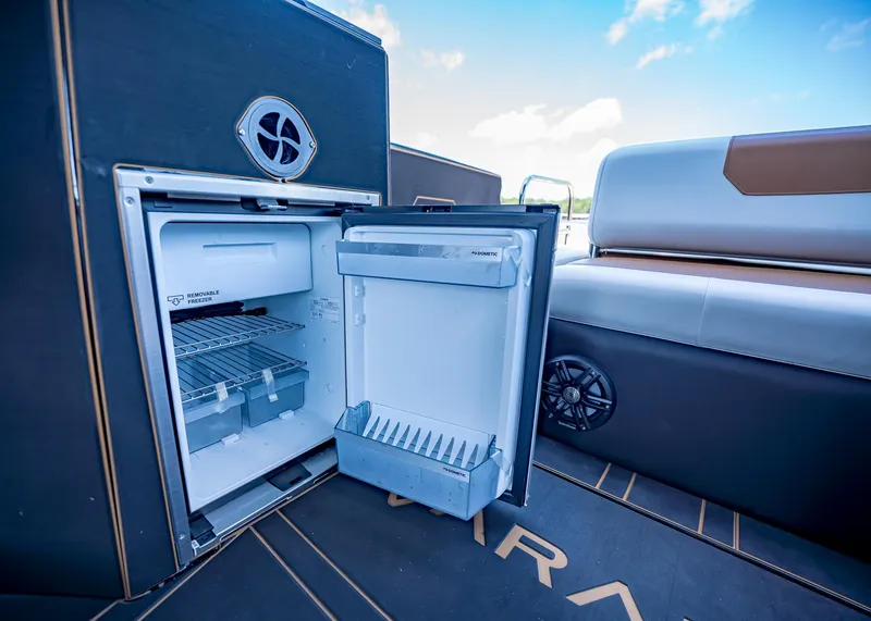 Slide: The Image of Open refrigerator on Paradigm 236 boat, showcasing interior storage and seating area, 2025 model. - 15
