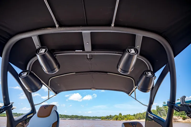 Slide: The Image of 2025 Paradigm 236 boat interior with speakers and canopy, overlooking a scenic river view. - 24