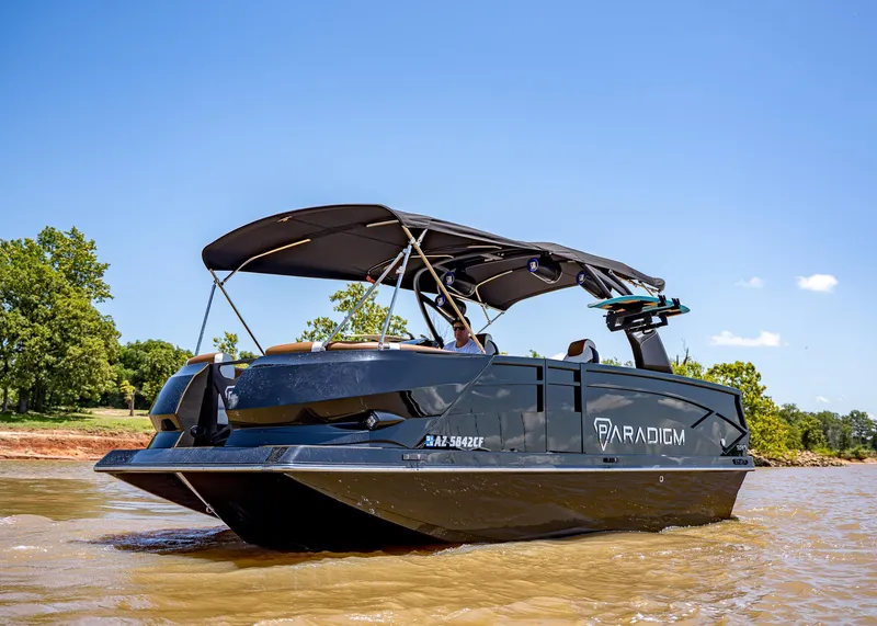 Slide: The Image of 2025 Paradigm 236 boat cruising on a sunny day, featuring sleek design and canopy. - 6