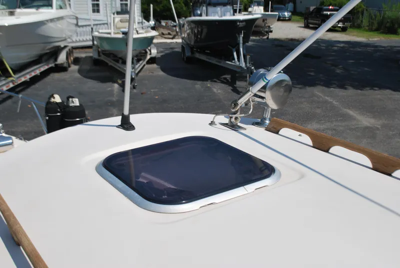 Slide: The Image of 2001 Atlas Boat Works Pompano 21 deck with hatch and antenna, docked with other boats. - 15