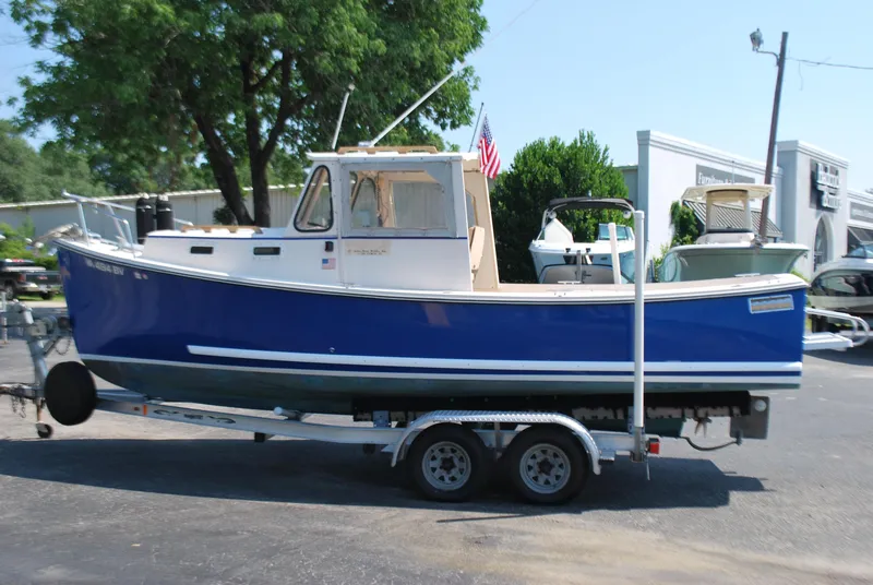 Slide: The Image of 2001 Atlas Boat Works Pompano 21 on trailer, blue hull, parked outdoors. - 3