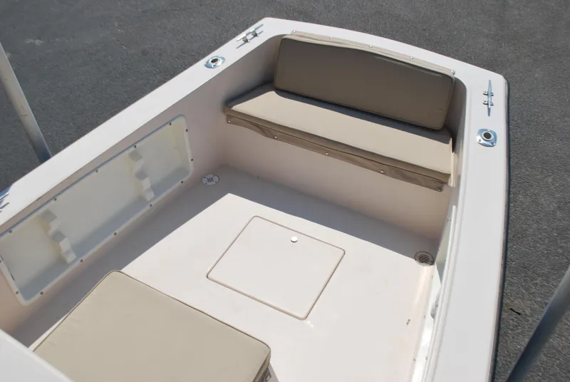 Slide: The Image of 2001 Atlas Boat Works Pompano 21 interior with beige seating and storage compartments. - 7