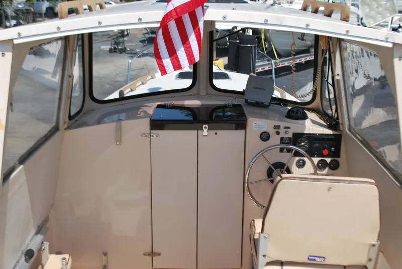 Slide: The Image of Interior view of 2001 Atlas Boat Works Pompano 21 with steering wheel and American flag. - 9