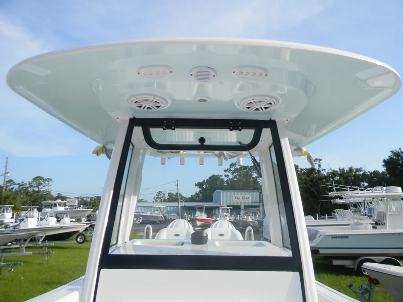 Slide: The Image of 2026 Sportsman Open 252 Center Console boat with T-top and speakers, docked outdoors. - 11