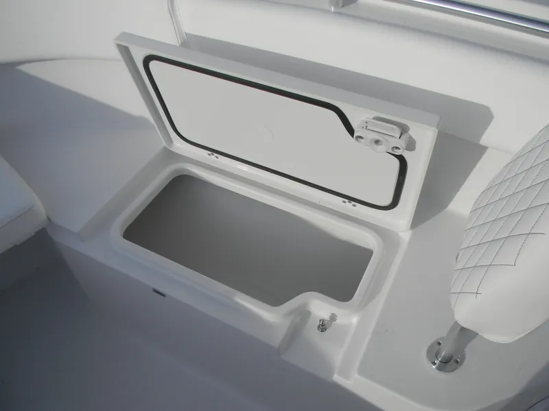 Slide: The Image of 2026 Sportsman Open 252 Center Console storage compartment with open lid and cushioned seat. - 12