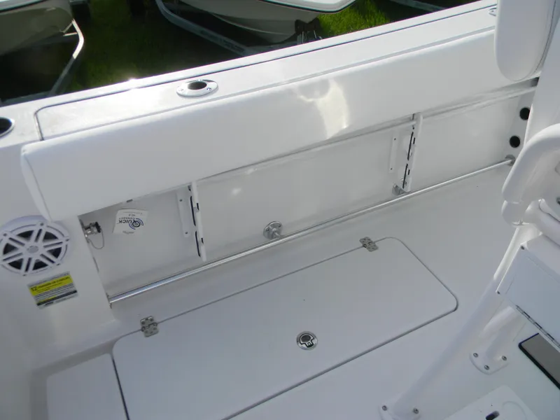 Slide: The Image of 2026 Sportsman Open 252 Center Console boat interior, featuring storage compartments and speaker. - 6