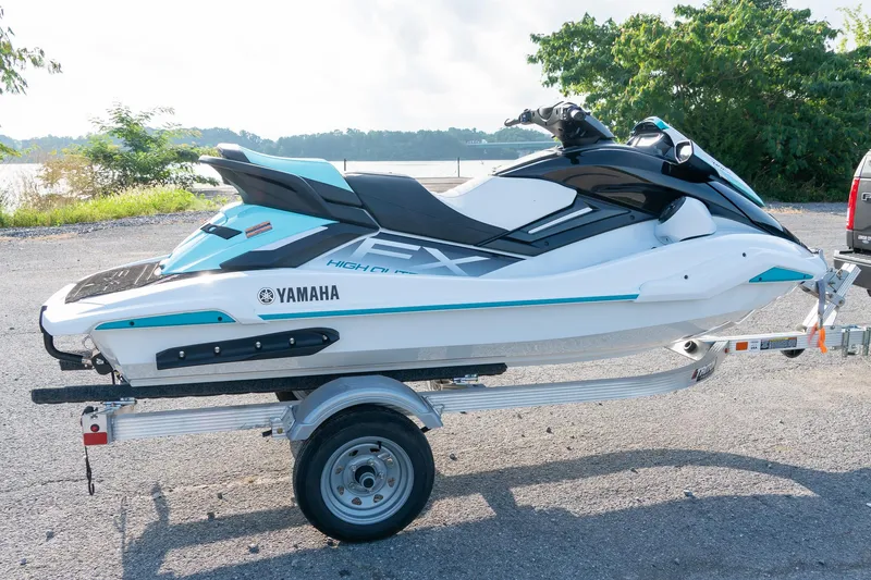 Slide: The Image of 2024 Yamaha WaveRunner FX Cruiser HO Audio on trailer, parked near a scenic waterfront. - 3