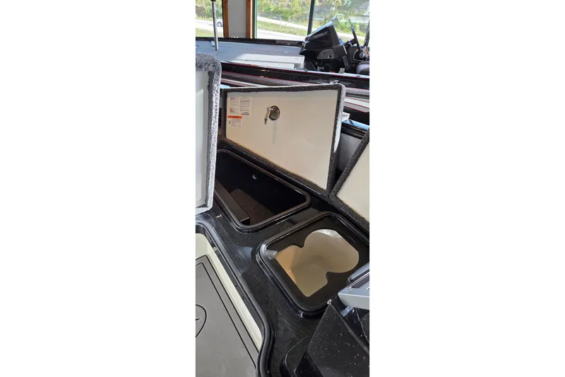 Slide: The Image of Open storage compartments in a 2025 Ranger 1880MS boat interior. - 14