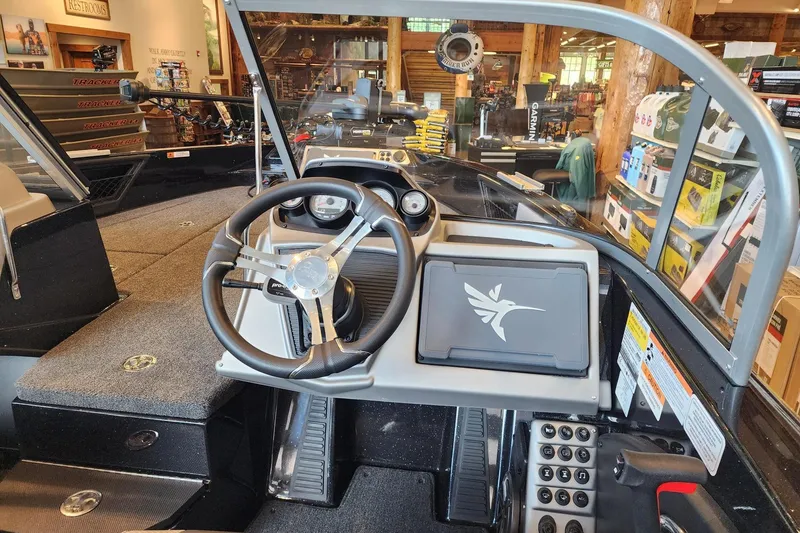 Slide: The Image of Interior view of 2025 Ranger 1880MS boat dashboard in a showroom setting. - 2