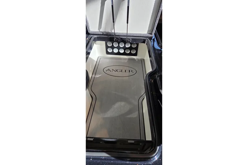 Slide: The Image of Open storage compartment in 2025 Ranger 1880MS boat, featuring "Angler" branding. - 16