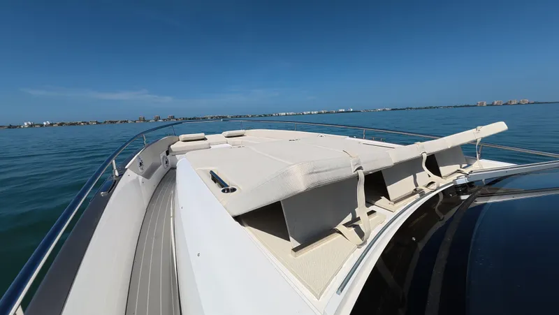 Slide: The Image of 2022 Azimut Verve 47 yacht deck with sun loungers on calm blue water. - 11