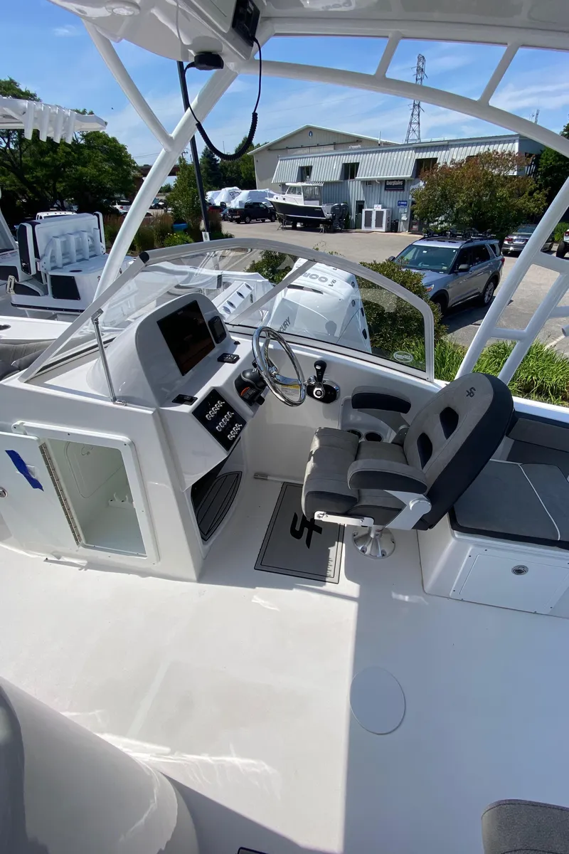 Slide: The Image of 2024 Sea Pro 240 Dual Console boat interior with helm and seating area. - 11
