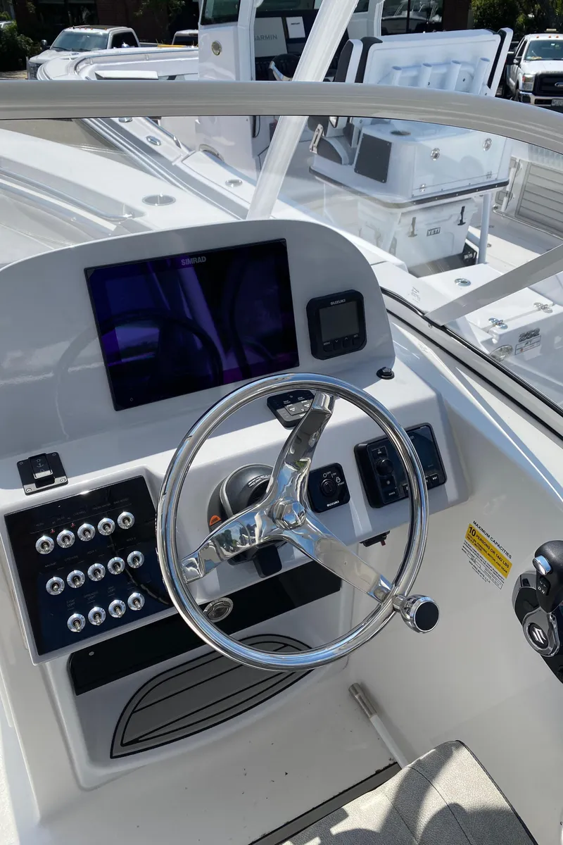 Slide: The Image of 2024 Sea Pro 240 Dual Console boat dashboard with steering wheel and control panel. - 12