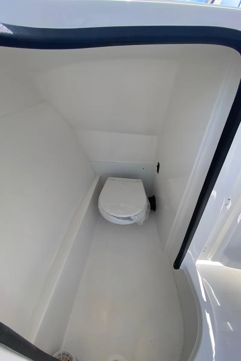 Slide: The Image of 2024 Sea Pro 240 Dual Console boat interior with compact marine toilet. - 18