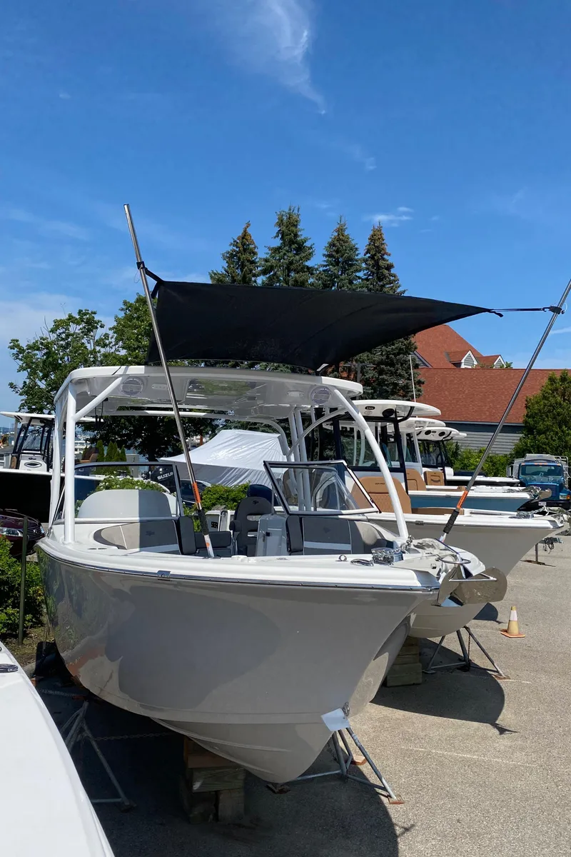 Slide: The Image of 2024 Sea Pro 240 Dual Console boat displayed outdoors under a clear blue sky. - 4