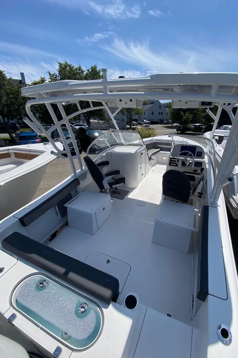 Slide: The Image of 2024 Sea Pro 240 Dual Console boat interior with seating, helm, and open deck under a clear sky. - 5