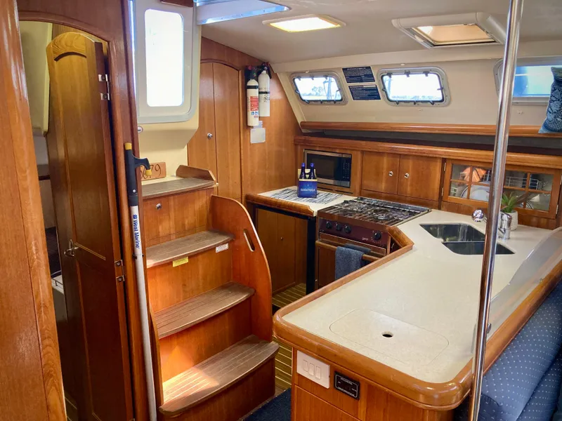 Slide: The Image of Interior of 2005 Hunter 41 AC sailboat with wooden cabinetry and modern kitchen amenities. - 12