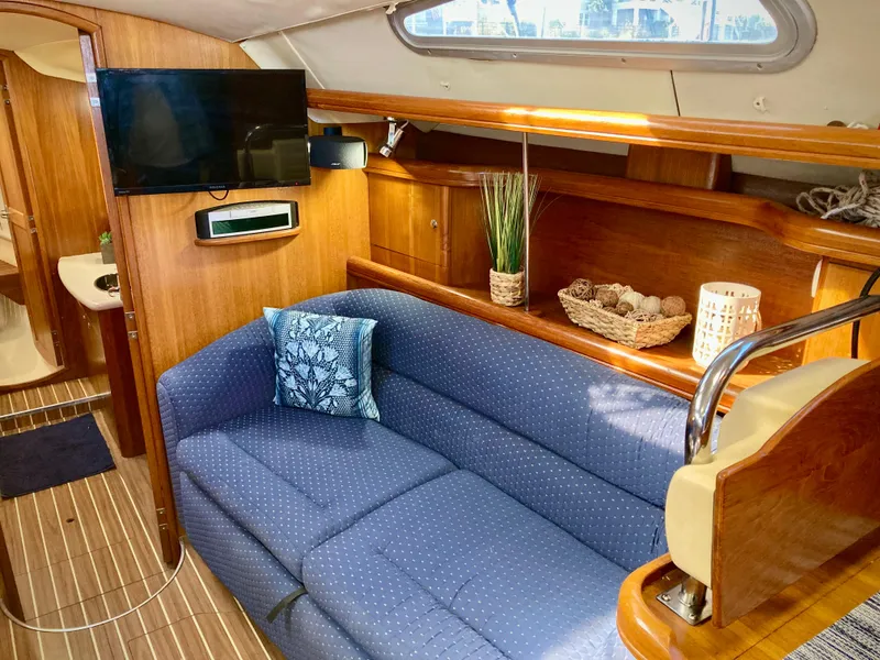 Slide: The Image of Interior of 2005 Hunter 41 AC yacht with blue sofa, TV, and wooden cabinetry. - 18