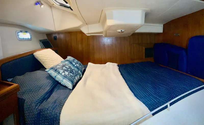 Slide: The Image of Cozy cabin interior of 2005 Hunter 41 AC sailboat with blue bedding and wooden paneling. - 22
