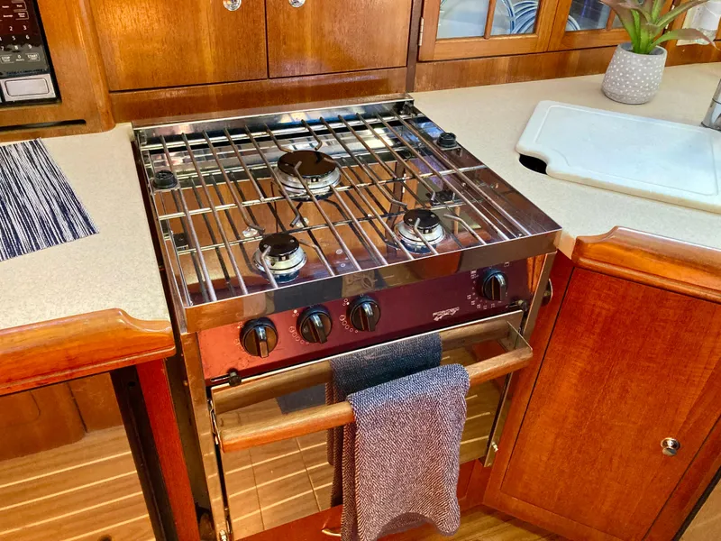 Slide: The Image of Galley kitchen in 2005 Hunter 41 AC sailboat with stove and wooden cabinetry. - 26