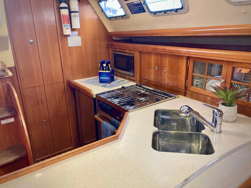 Slide: The Image of Interior of 2005 Hunter 41 AC yacht kitchen with stove, sink, and wooden cabinetry. - 28