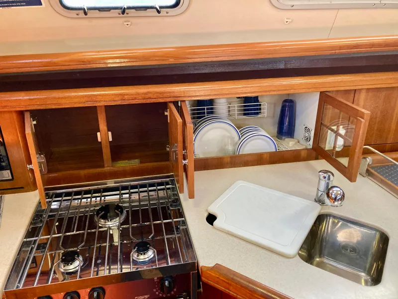 Slide: The Image of Galley kitchen in 2005 Hunter 41 AC sailboat with stove, sink, and dish storage. - 32